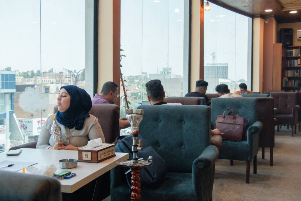 Manar fume la chicha dans un café de Mossoul. 